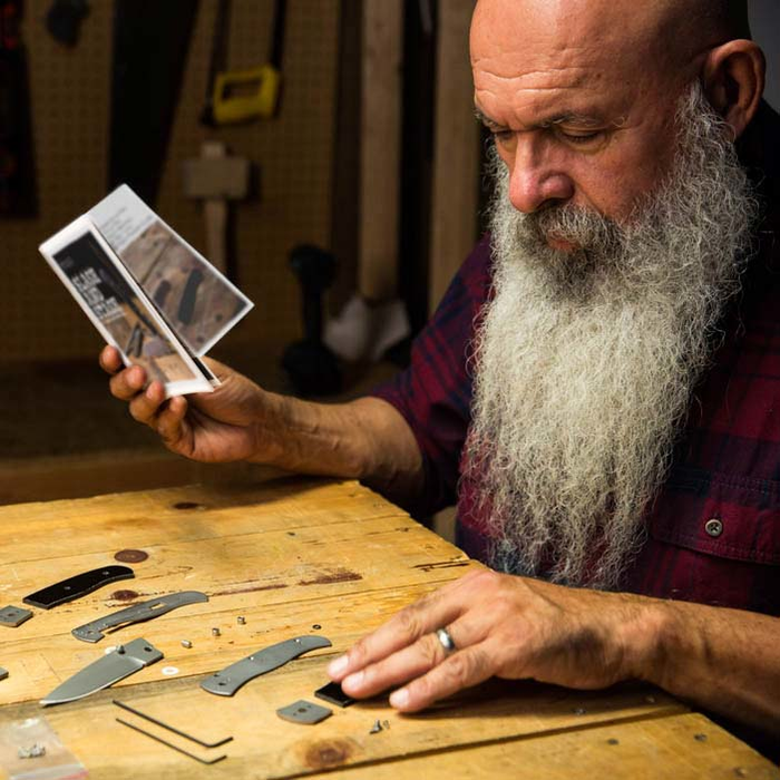 Man with white beard looking at directions to make knife for men's gift.