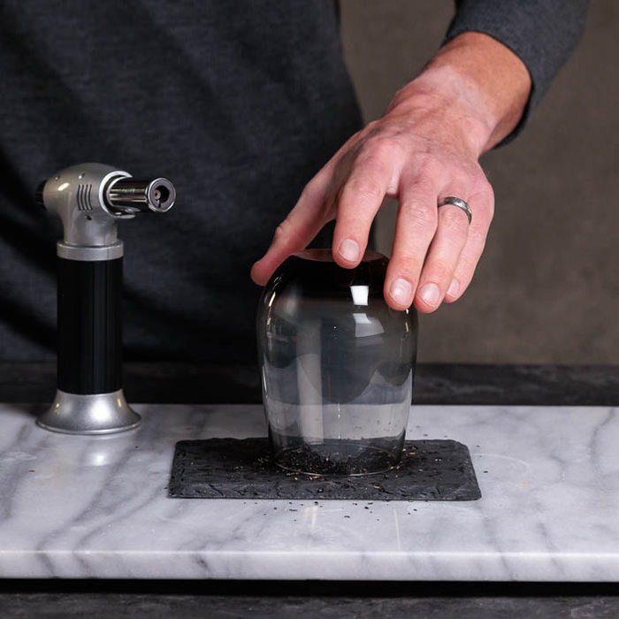 Rocks glass covering chips trapping smoke is a great men's cocktail gift.